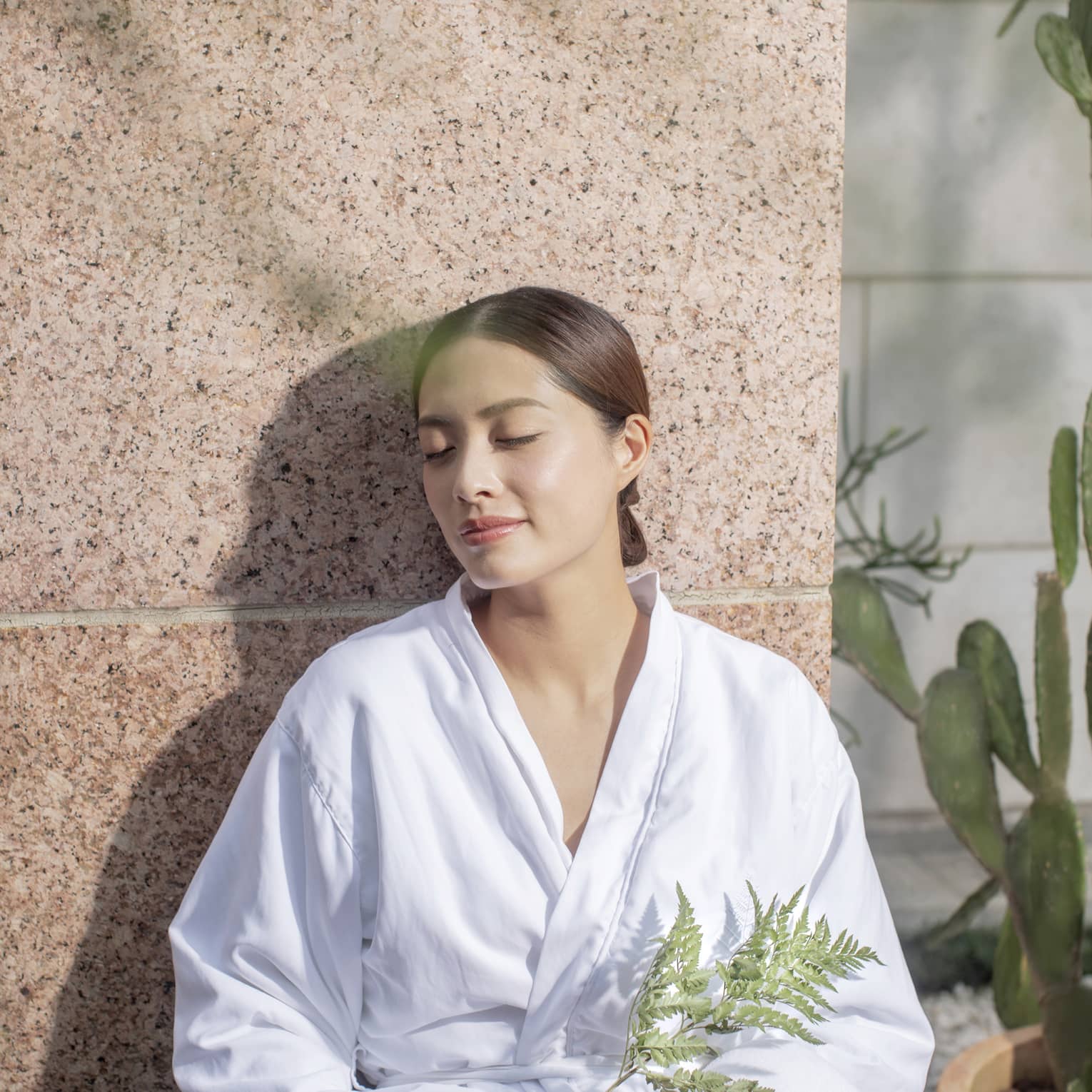 A woman in a spa robe enjoying the afterglow of a massage at the Four Seasons Hong Kong Spa.