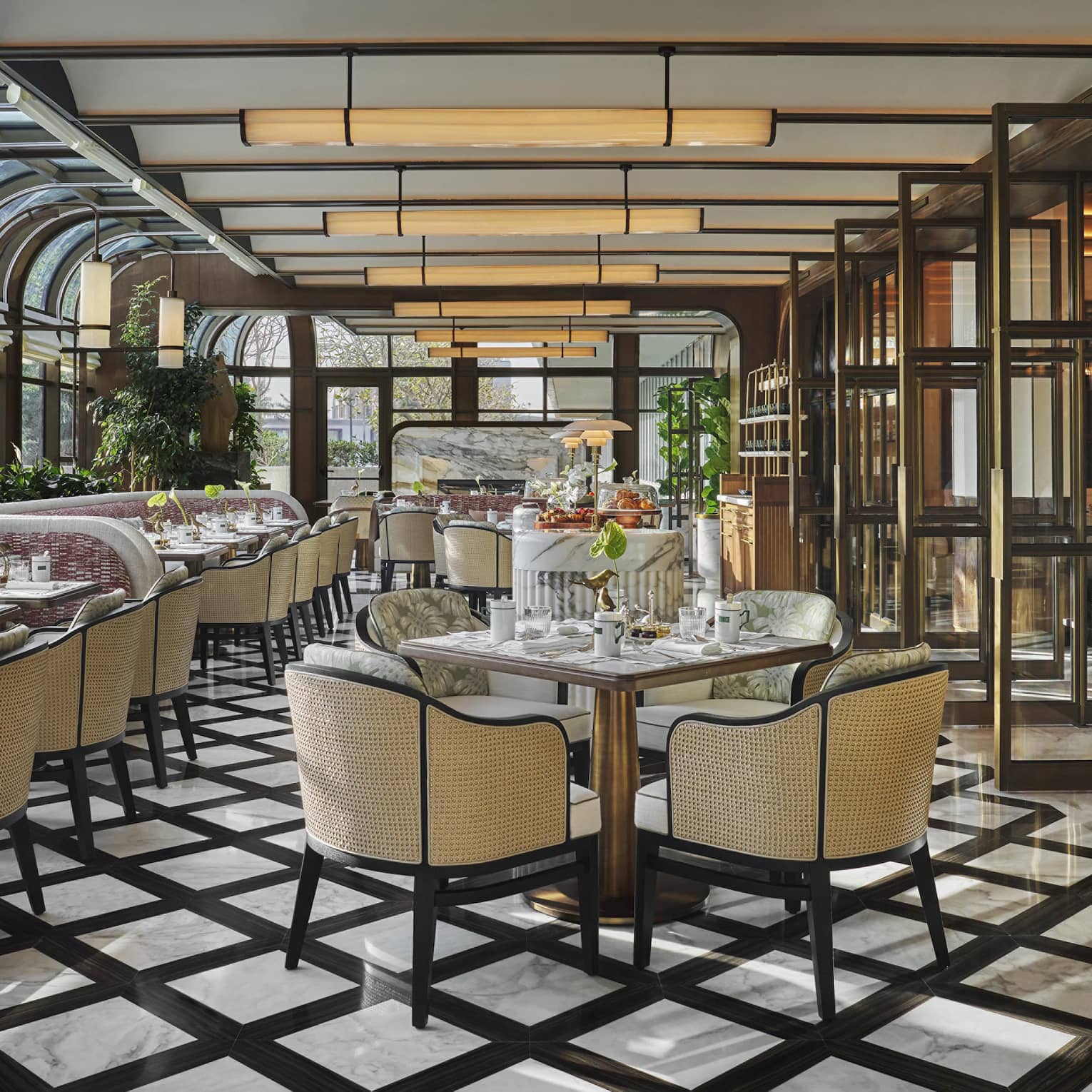Restaurant dining room with black-and-white tiled floors, wicker-backed dining chairs and a conservatory-style ceiling
