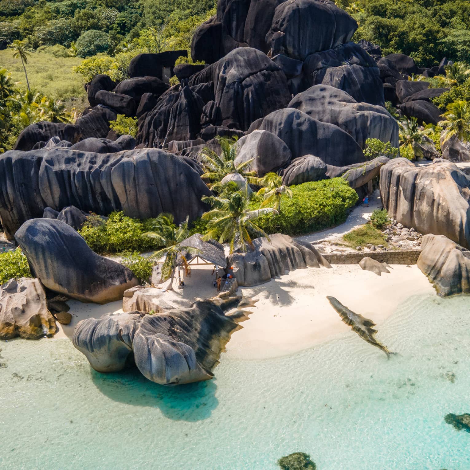 Rocky island white-sand beach with clear turquoise water