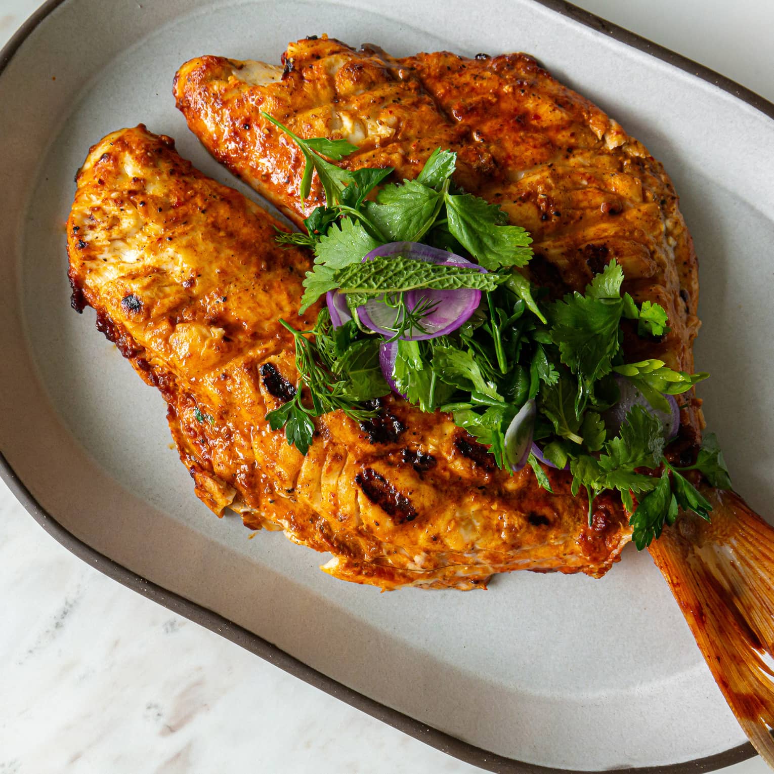 Cooked fish on a white plate.