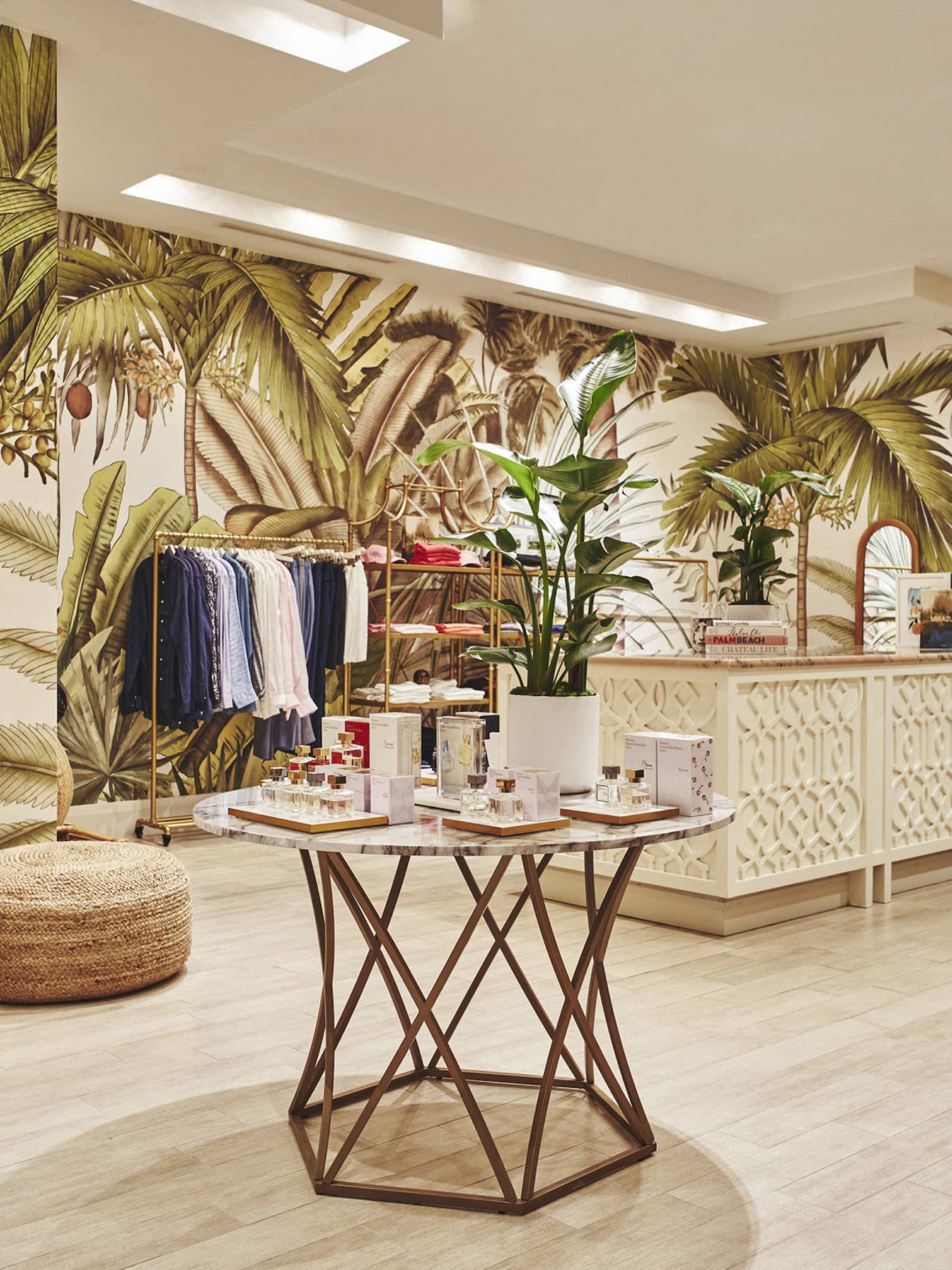 A brightly lit store with light wood features and clothes on shelves and hangers.