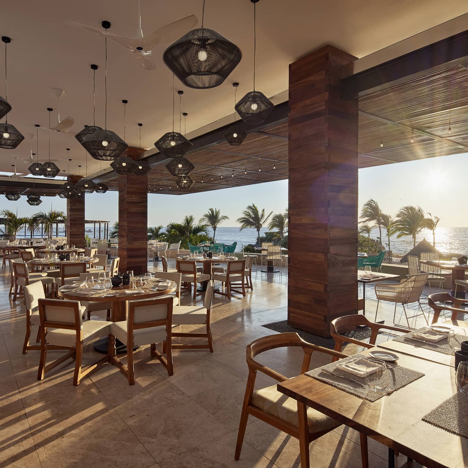 Sun streams into open air dining room with modern wood pillars