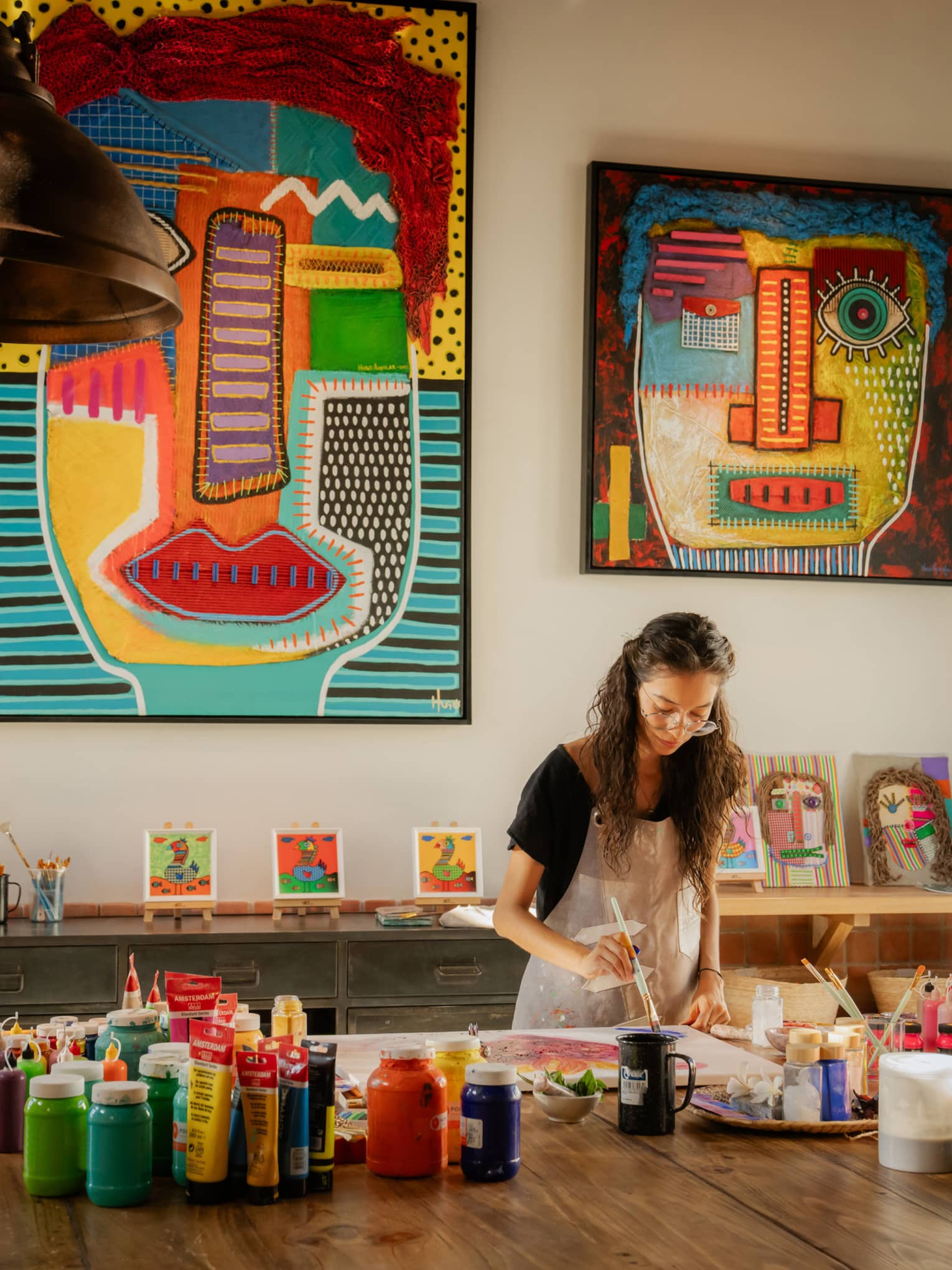 Woman paints in colourful art studio at luxury resort