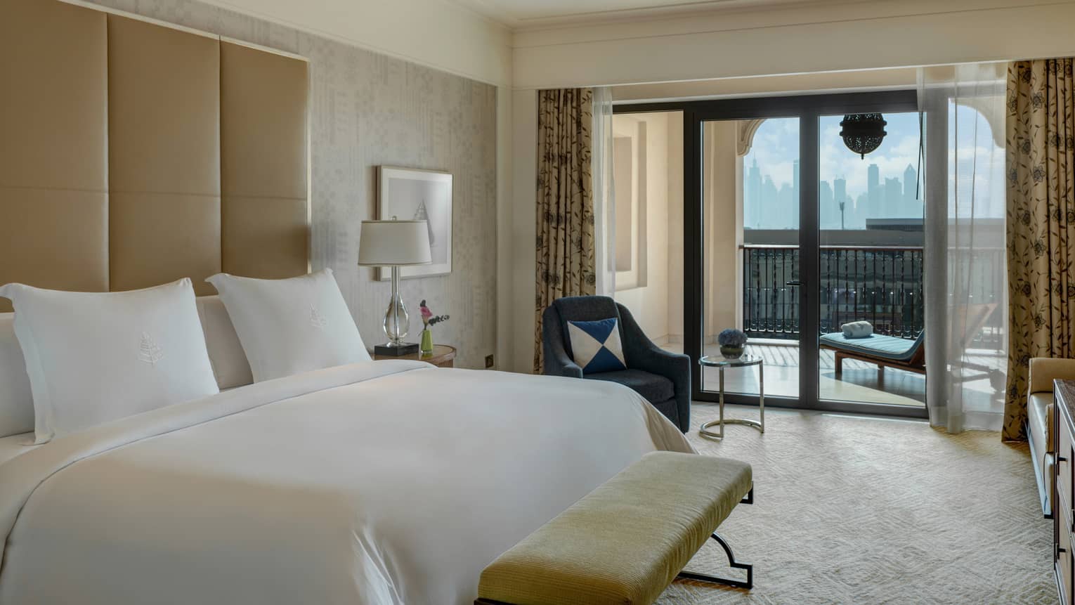 Bedroom with king bed, white sheets, tan headboard, balcony