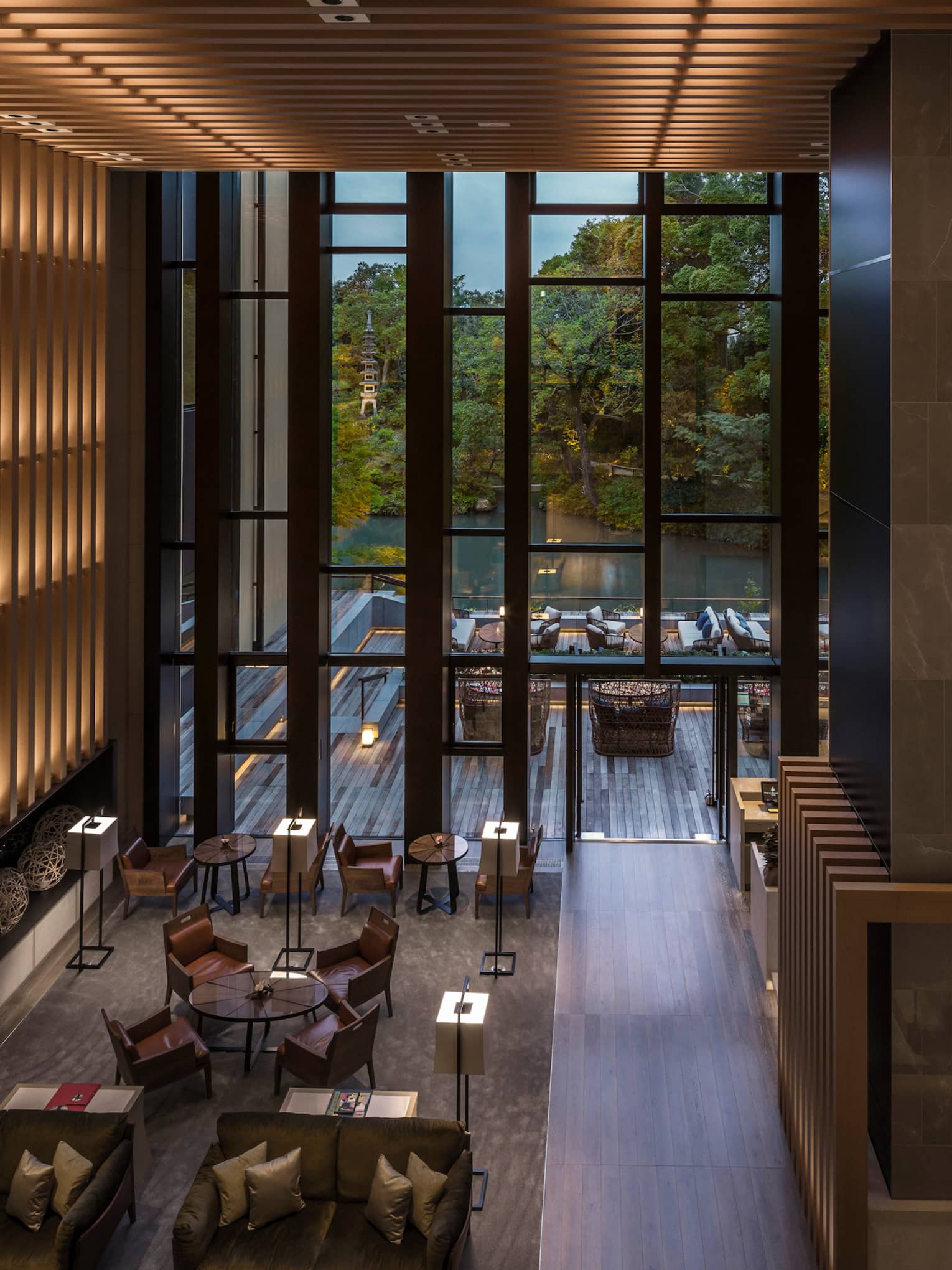 Looking down from soaring ceilings over Brasserie restaurant dining room, wood wall with lights