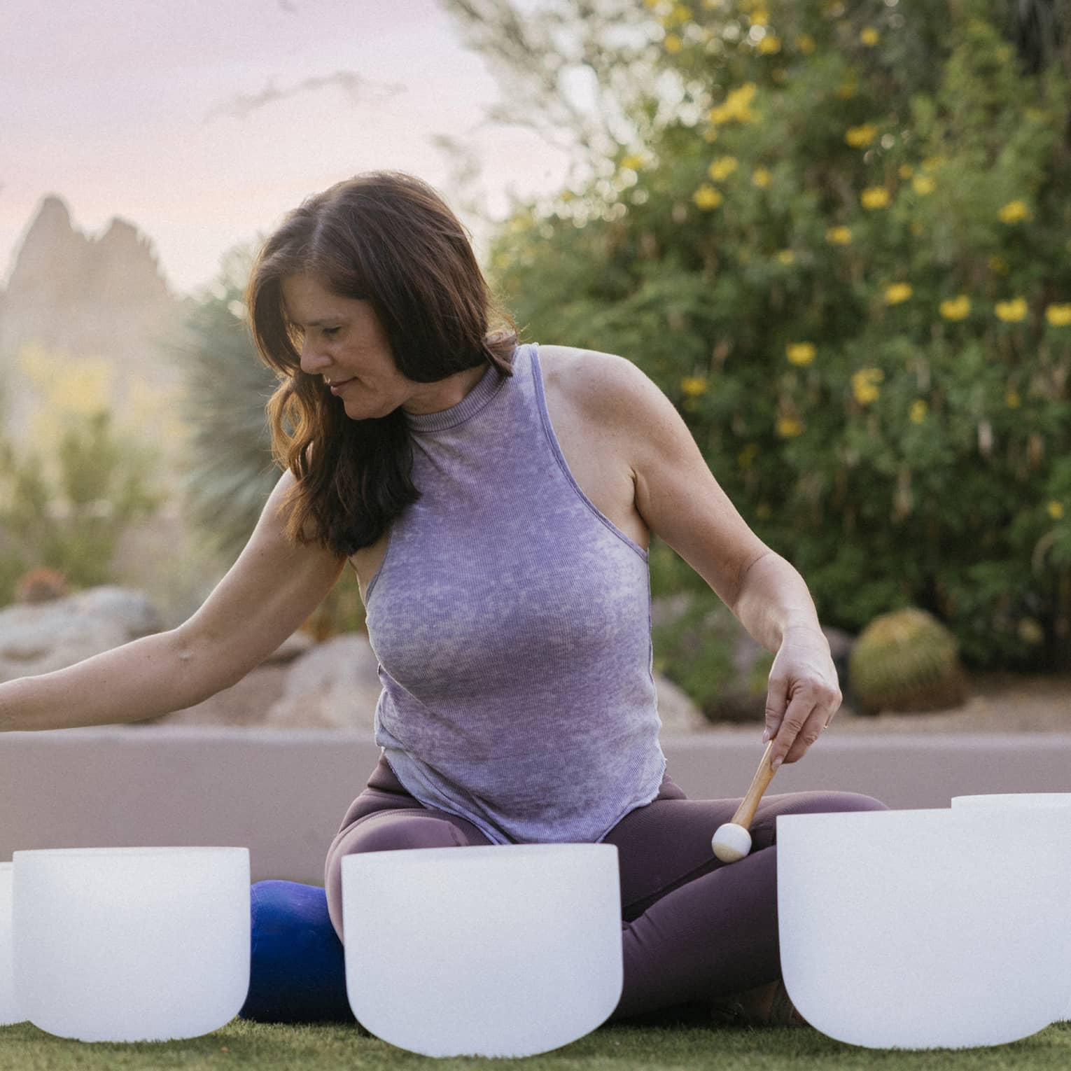 Person sitting outside doing a sound bowl meditation.