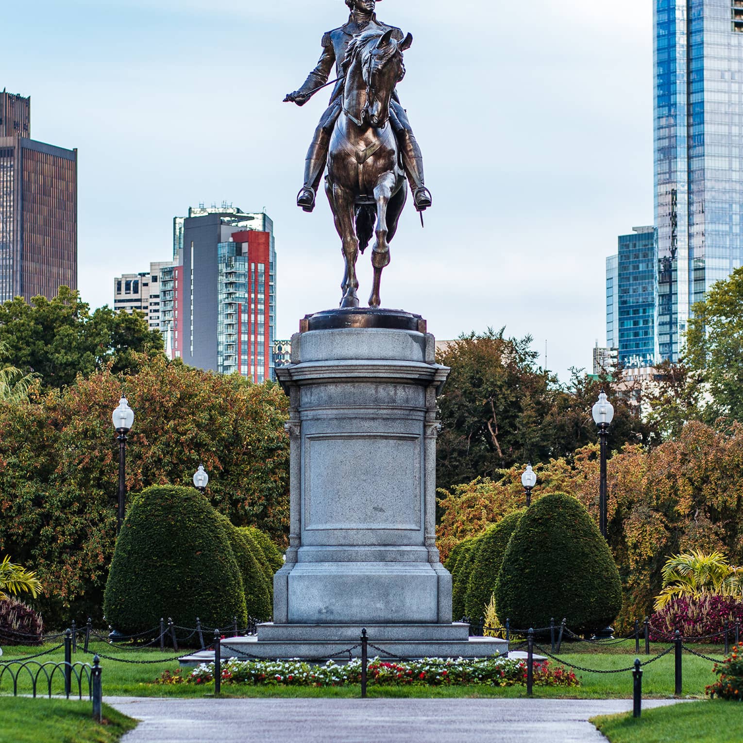 A large statue of a man on horseback in the middle of a garden.