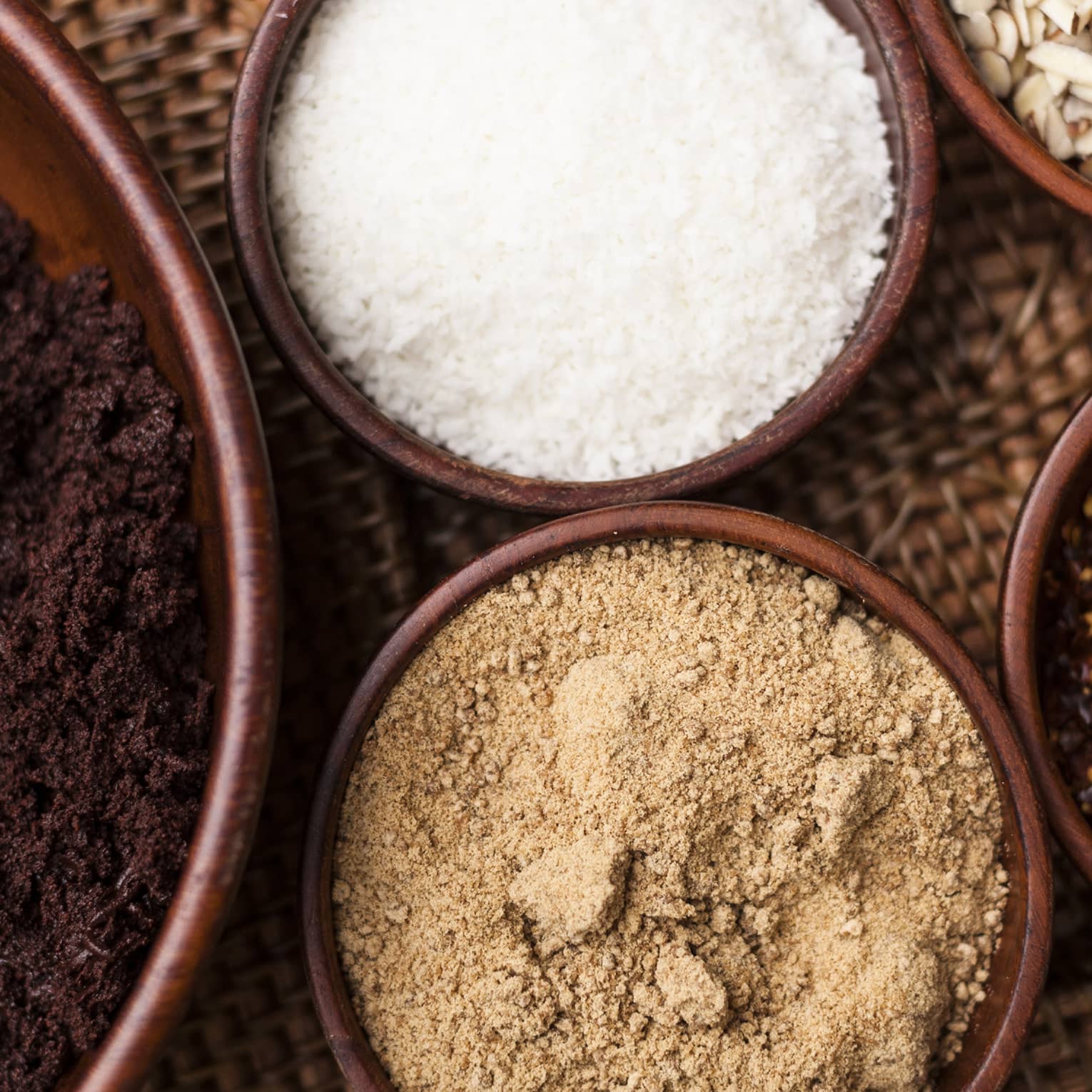 Small bowls of ground roasted cocoa beans, sugar, red chiles