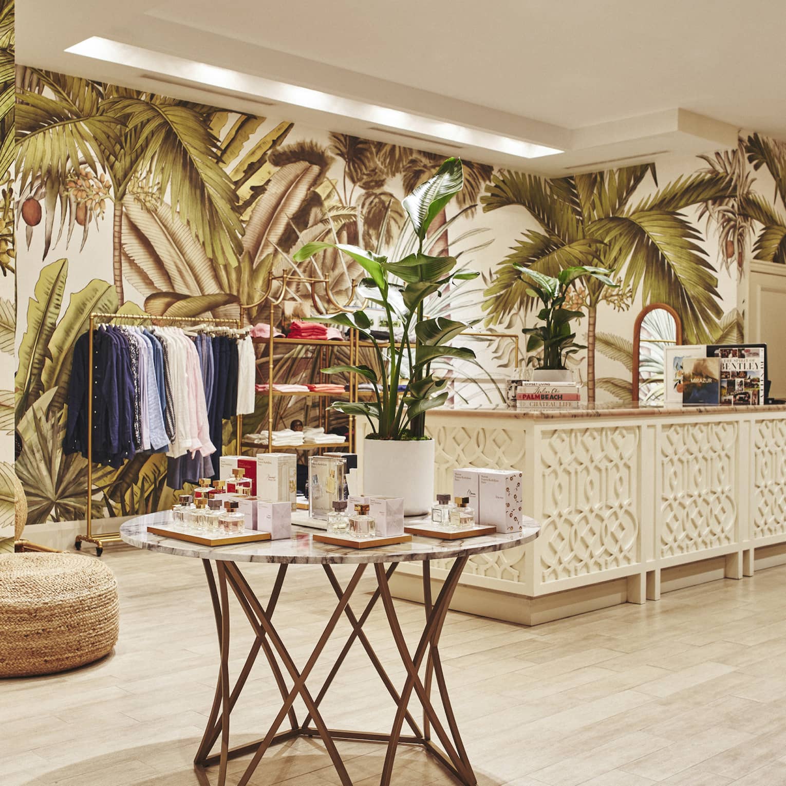 A brightly lit store with light wood features and clothes on shelves and hangers.