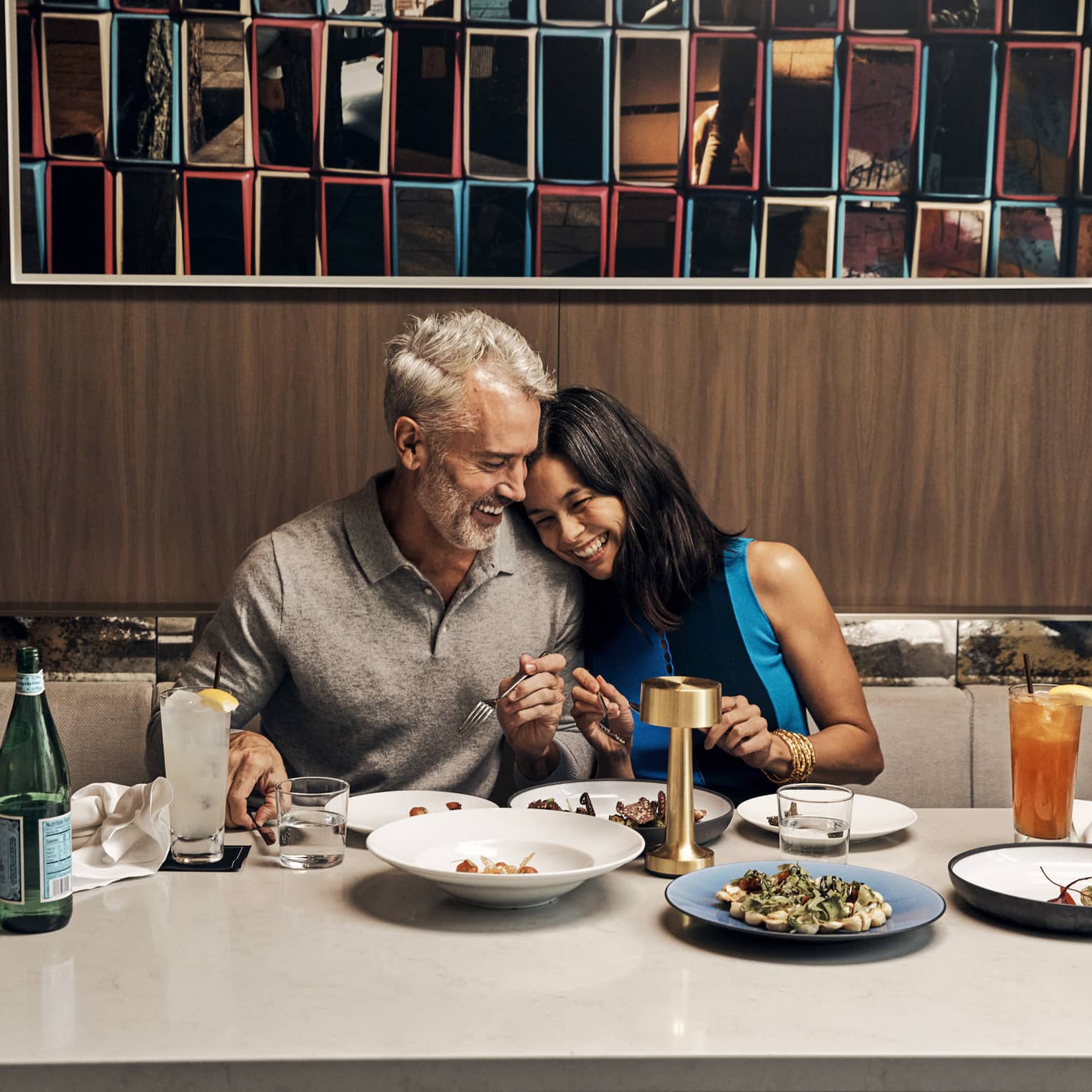 A man and woman eating food at a large table.