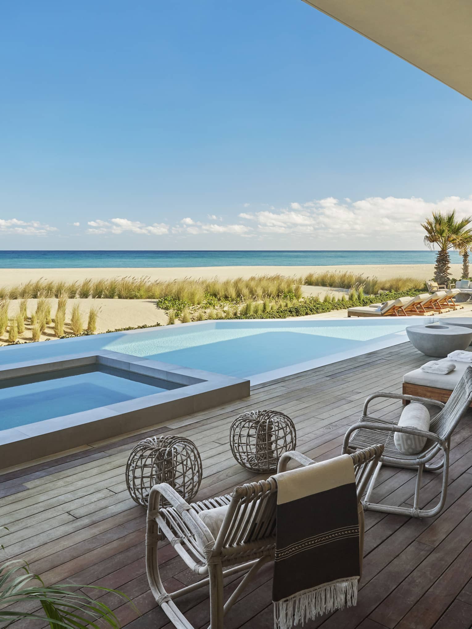 Private pool terrace with high-end lounge beds and chairs, and view of beach and sea, at Four Seasons Resort and Residences Los Cabos