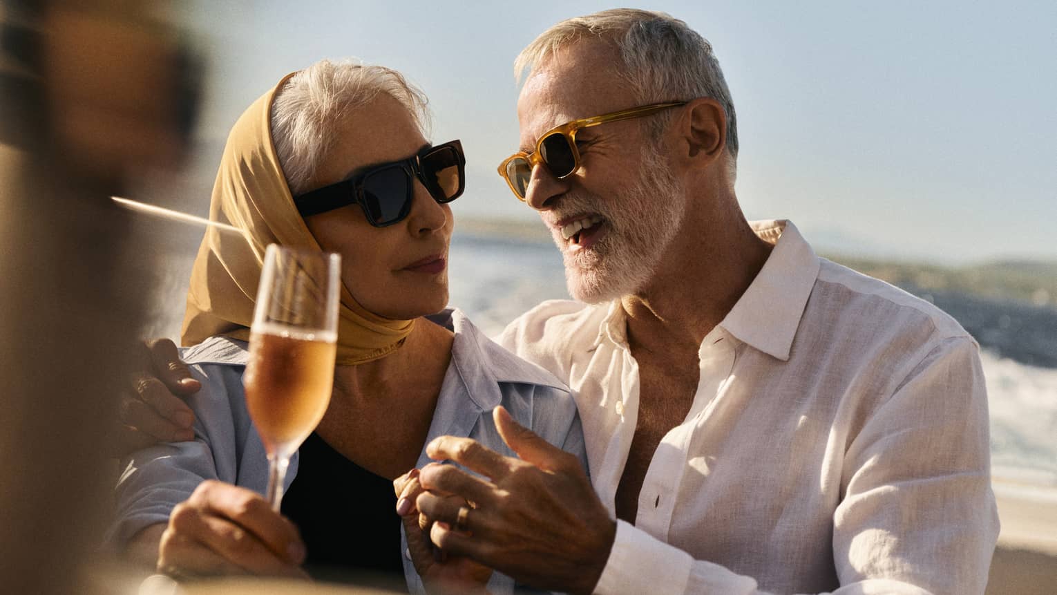 Two people enjoy drinks on a boat.