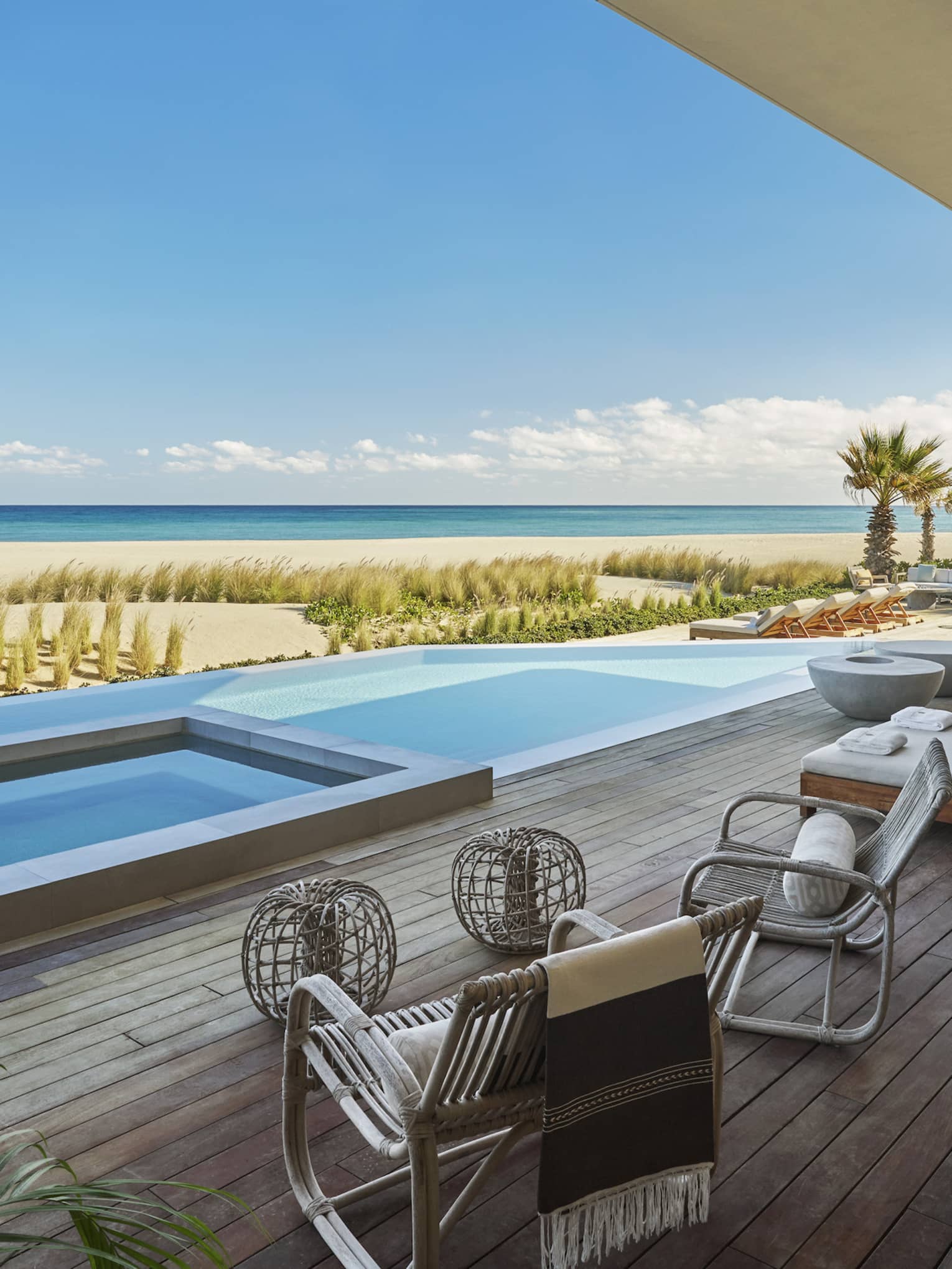 Private pool terrace with high-end lounge beds and chairs, and view of beach and sea, at Four Seasons Resort and Residences Los Cabos