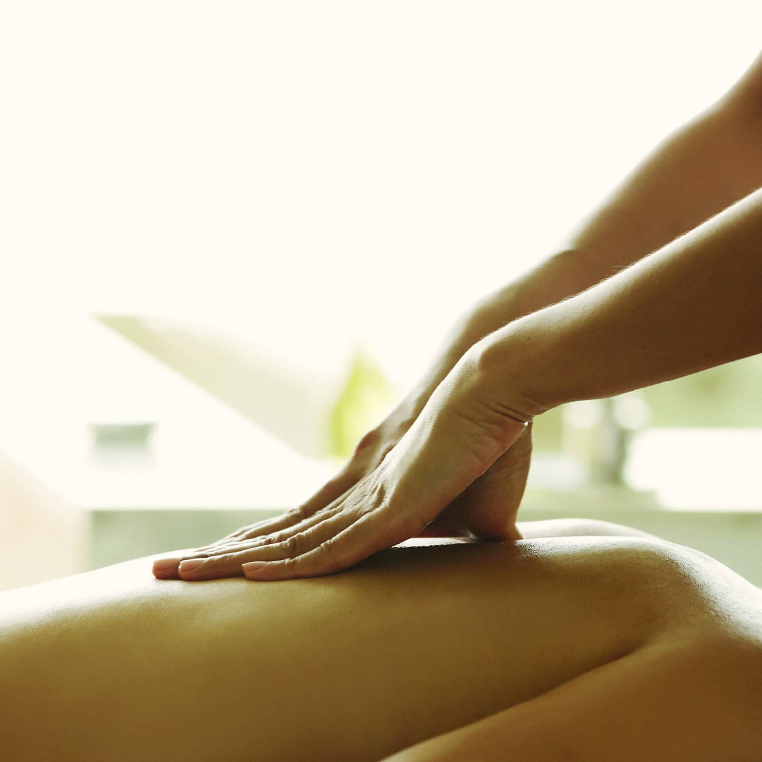 Close-up of a person receiving a relaxing back massage in a spa setting.