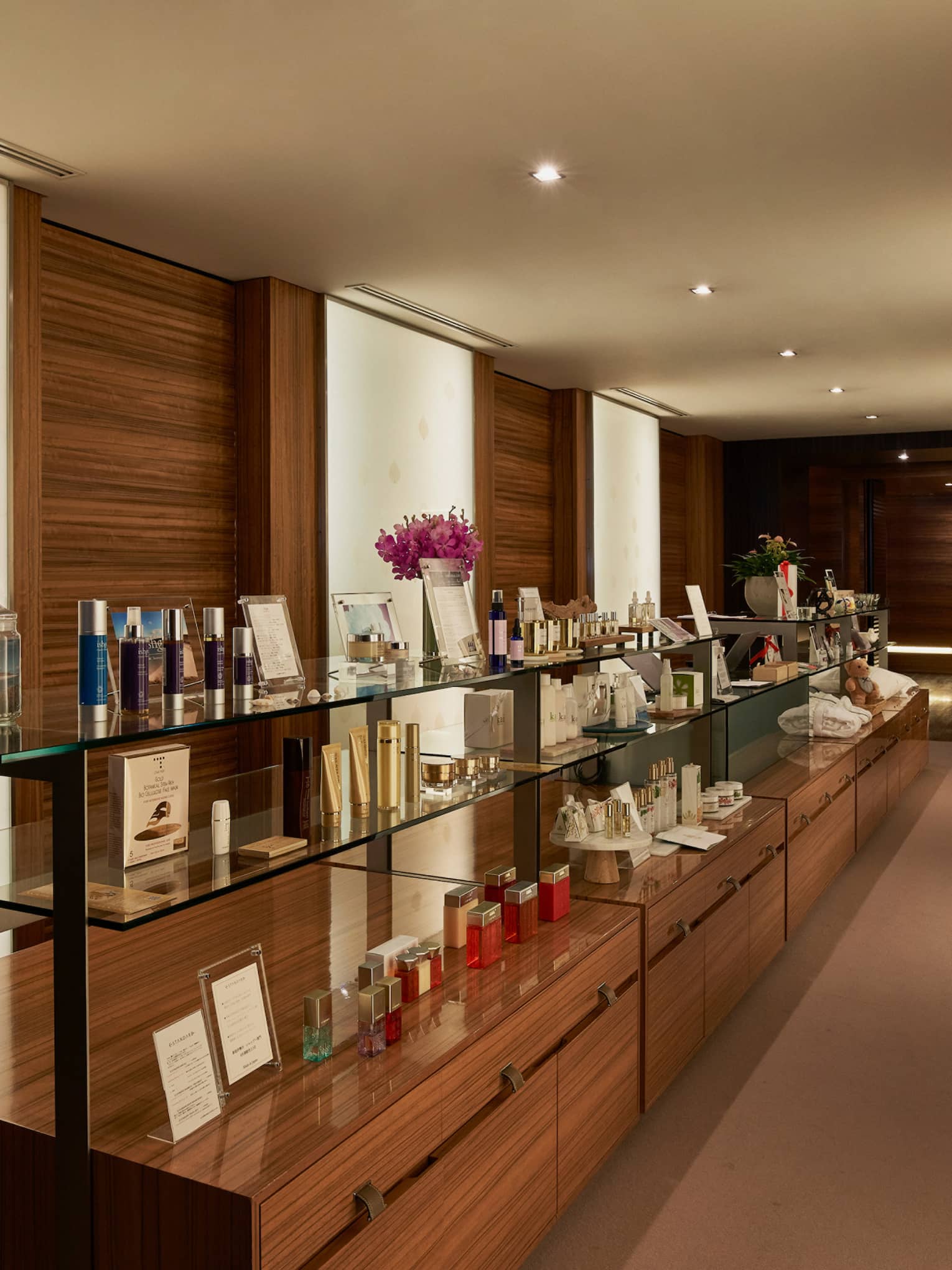 Wood and glass display shelves with boutique items in dimly lit hallway