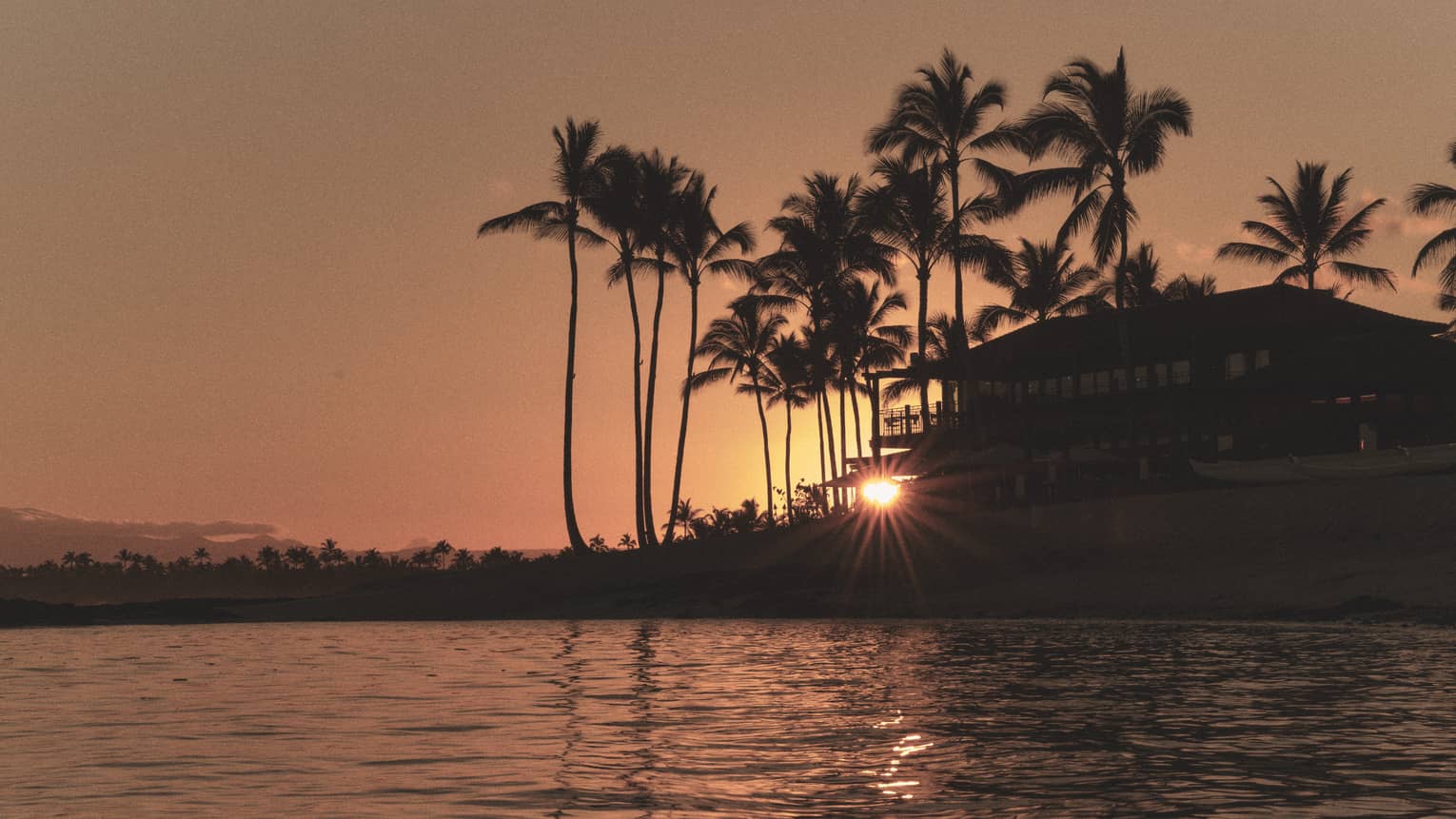 Tropical resort on the water at sunset