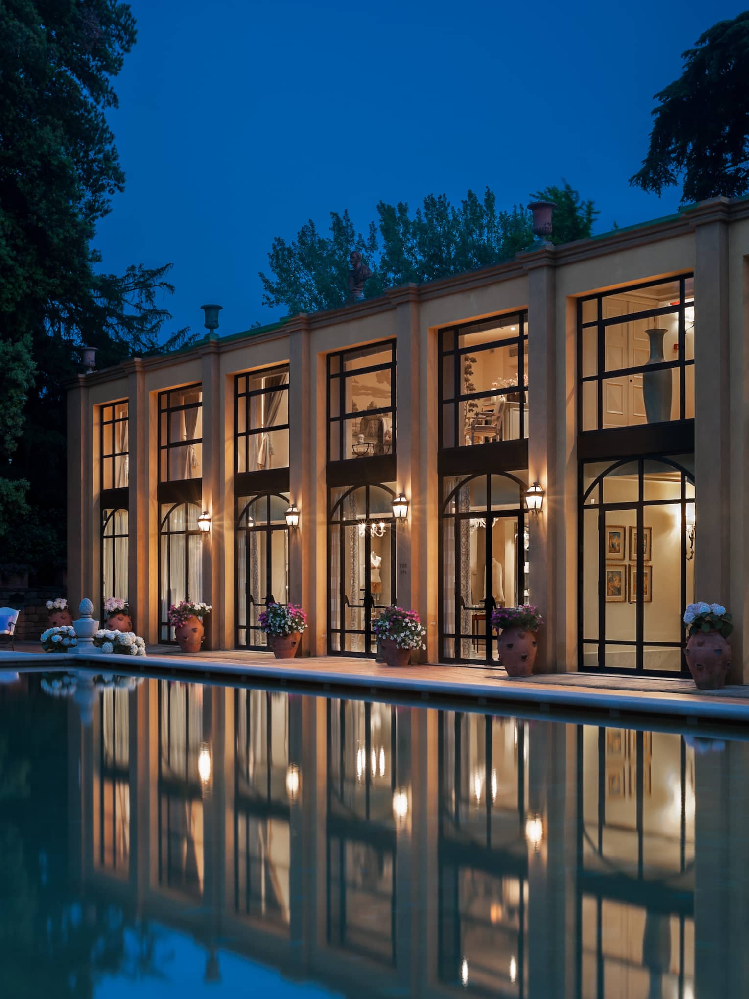 Four Seasons Hotel Florence two-level exterior with large picture windows overlooking pool at night