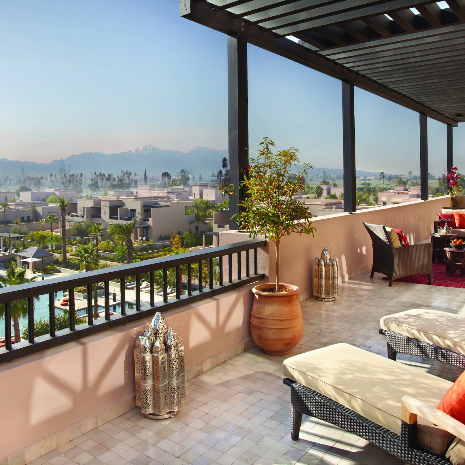 Two lounge chairs on the terrace of the Presidential Suite overlooking a pool at Four Seasons Marrakech