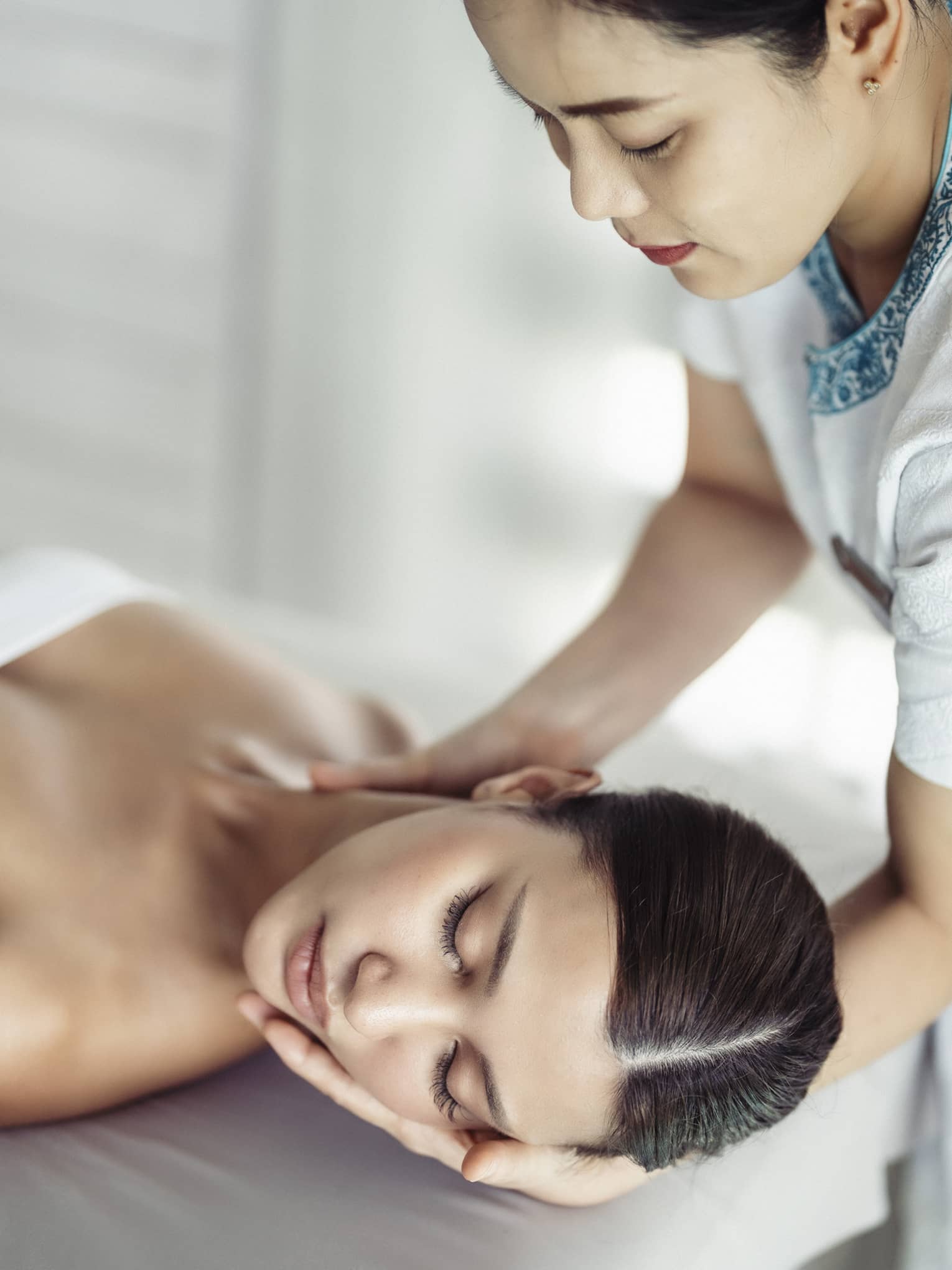 A woman in a spa receiving chiropracty.