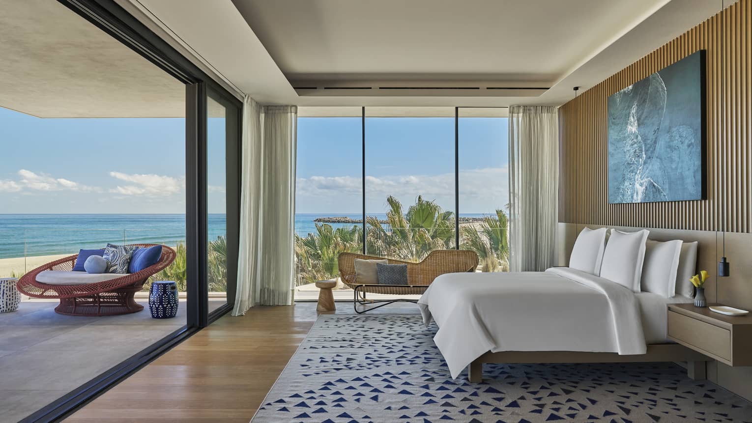 Large bedroom with king beds, walls of windows/sliding glass door to a private terrace with sea view, at Four Seasons Resort and Residences Los Cabos