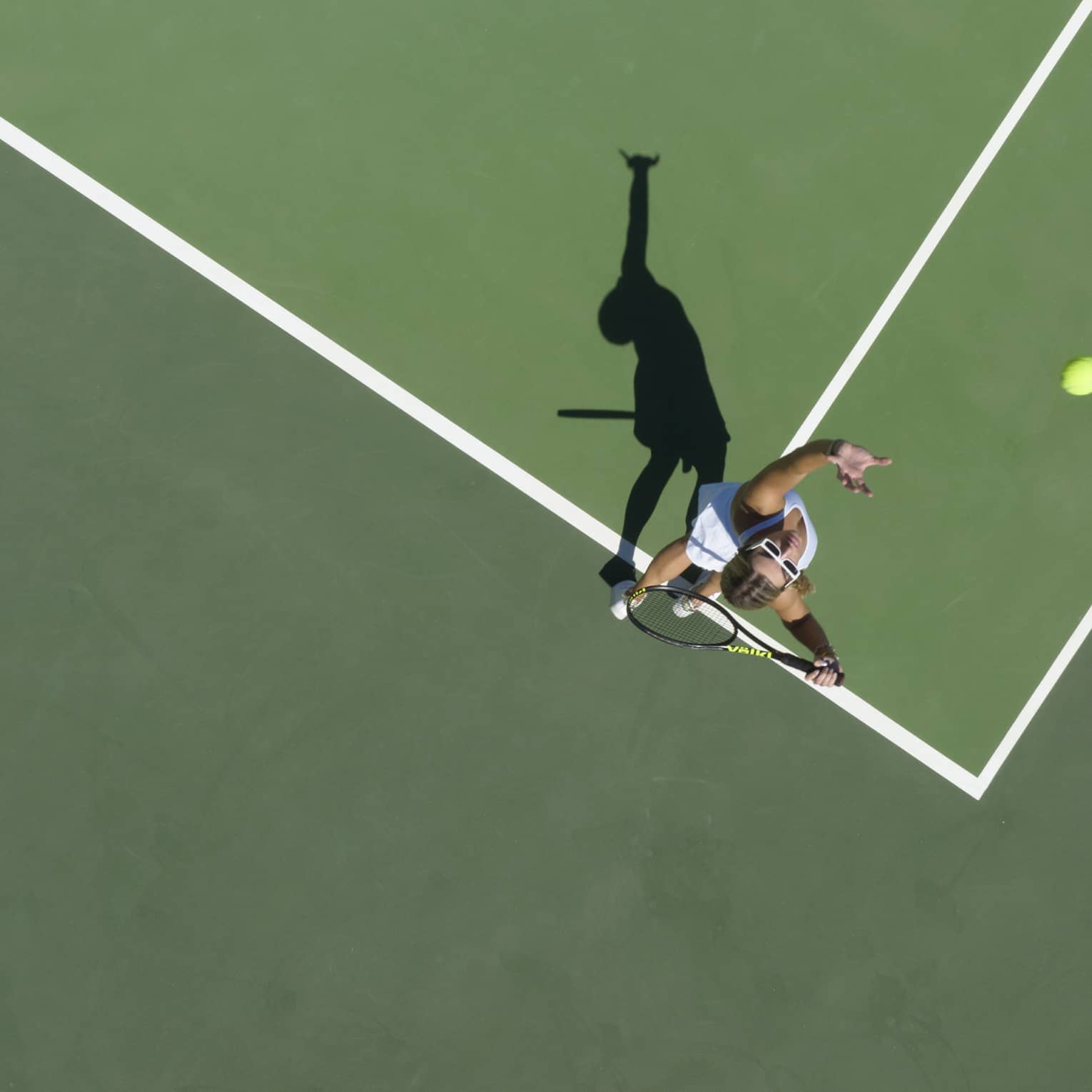 Aerial view of a tennis player mid serve