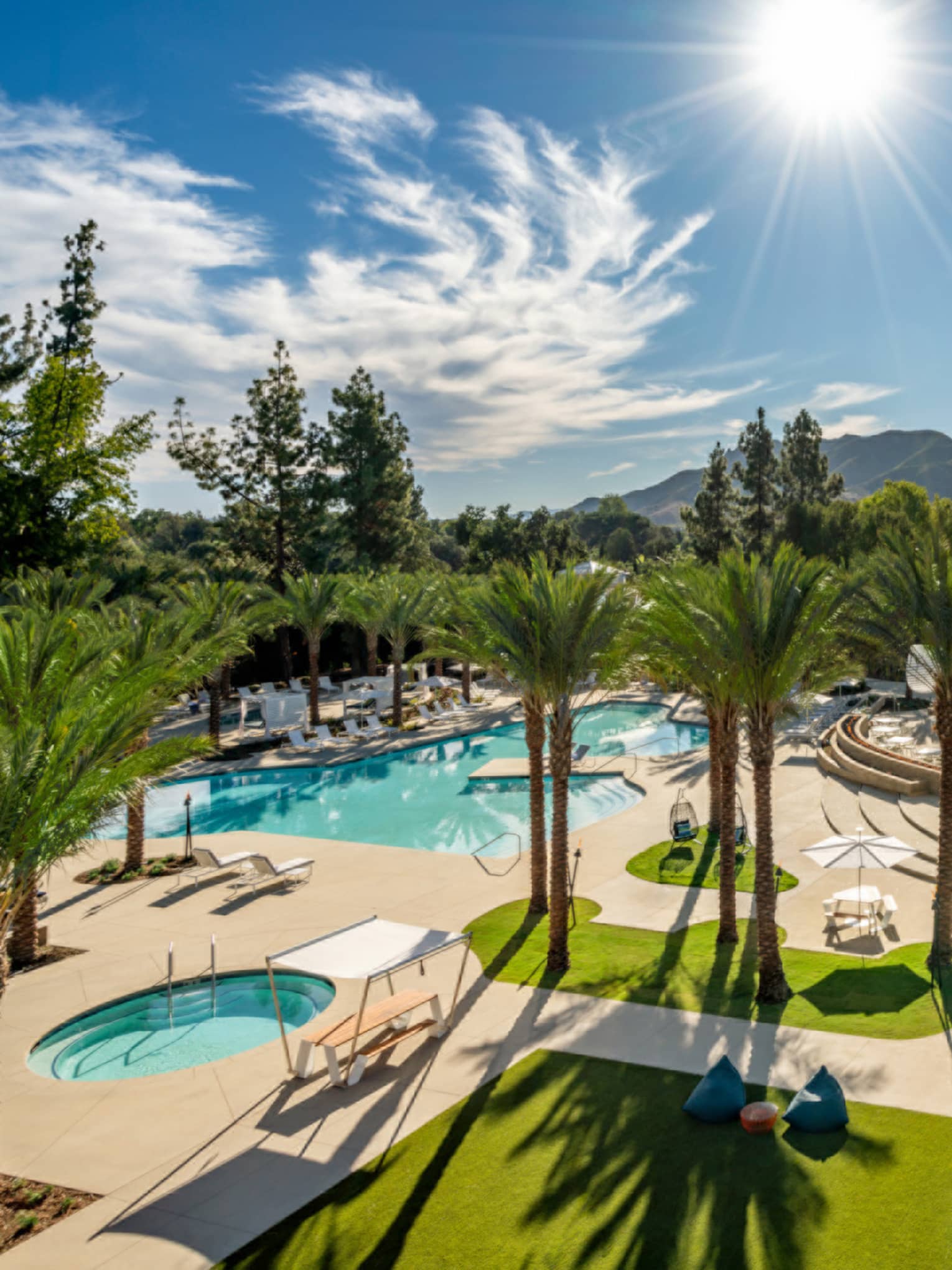 Aerial view of the pool with sunlight and palm trees.