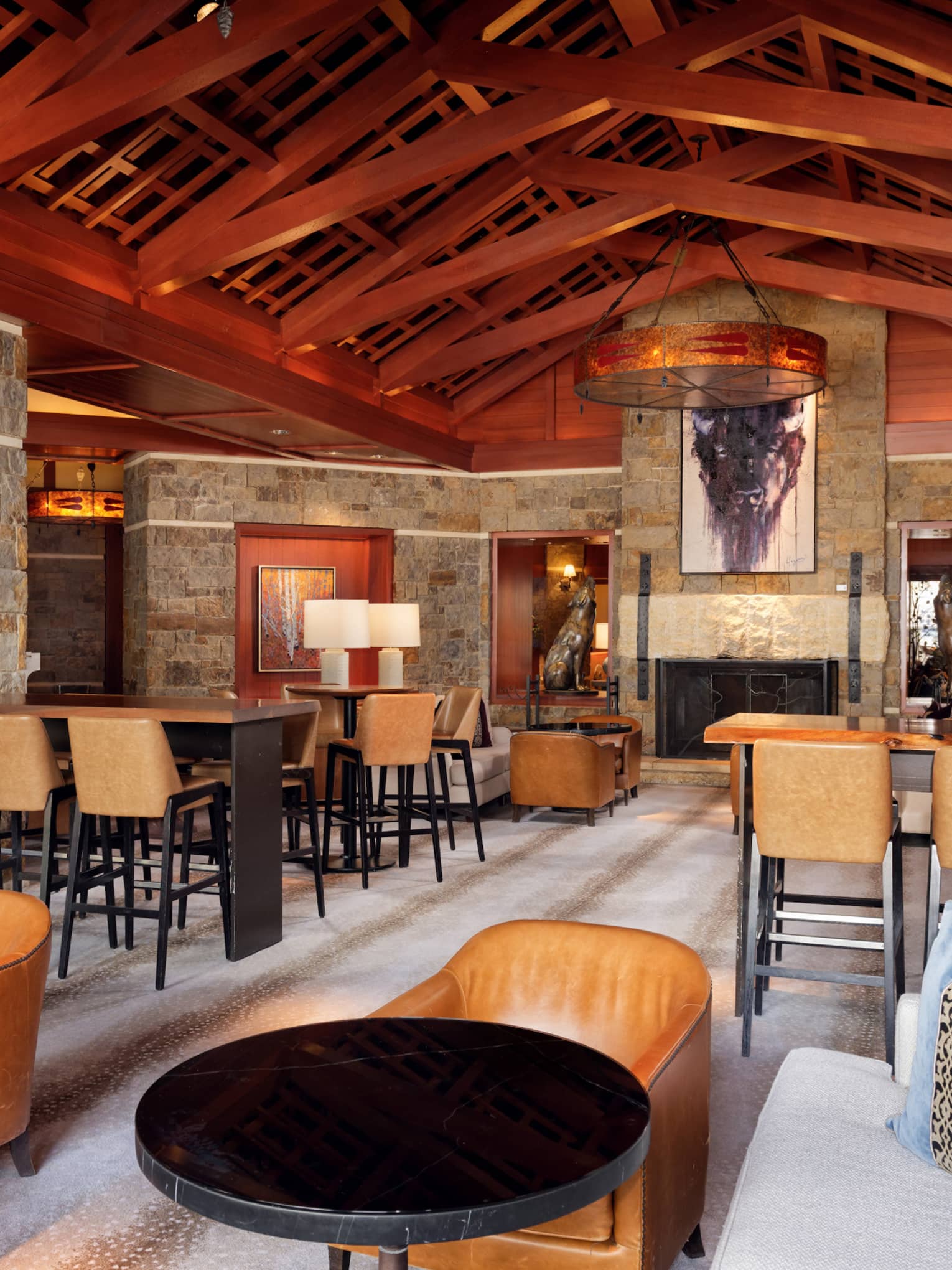 A lounge area with wood details, sofas, wood tables and chairs.