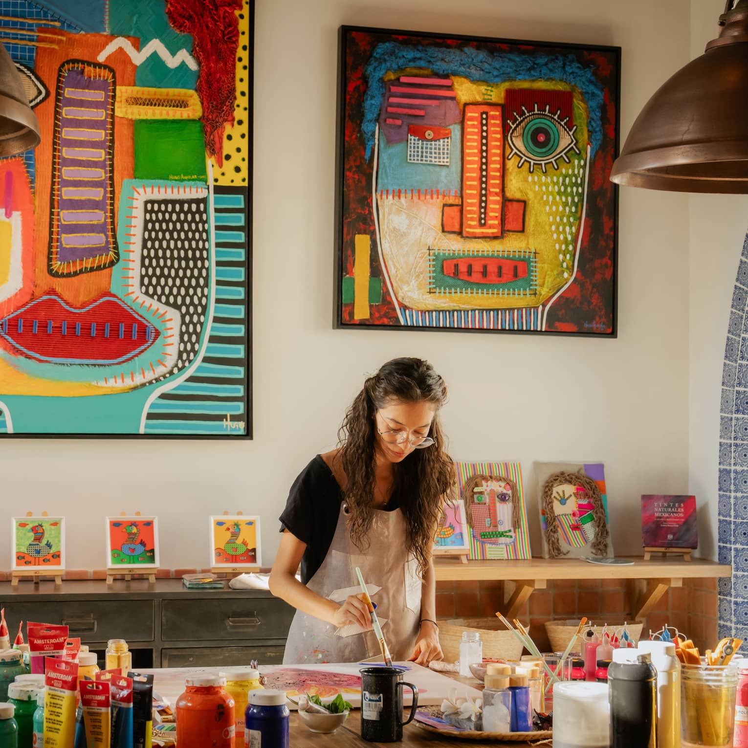 Woman paints in colourful art studio at luxury resort