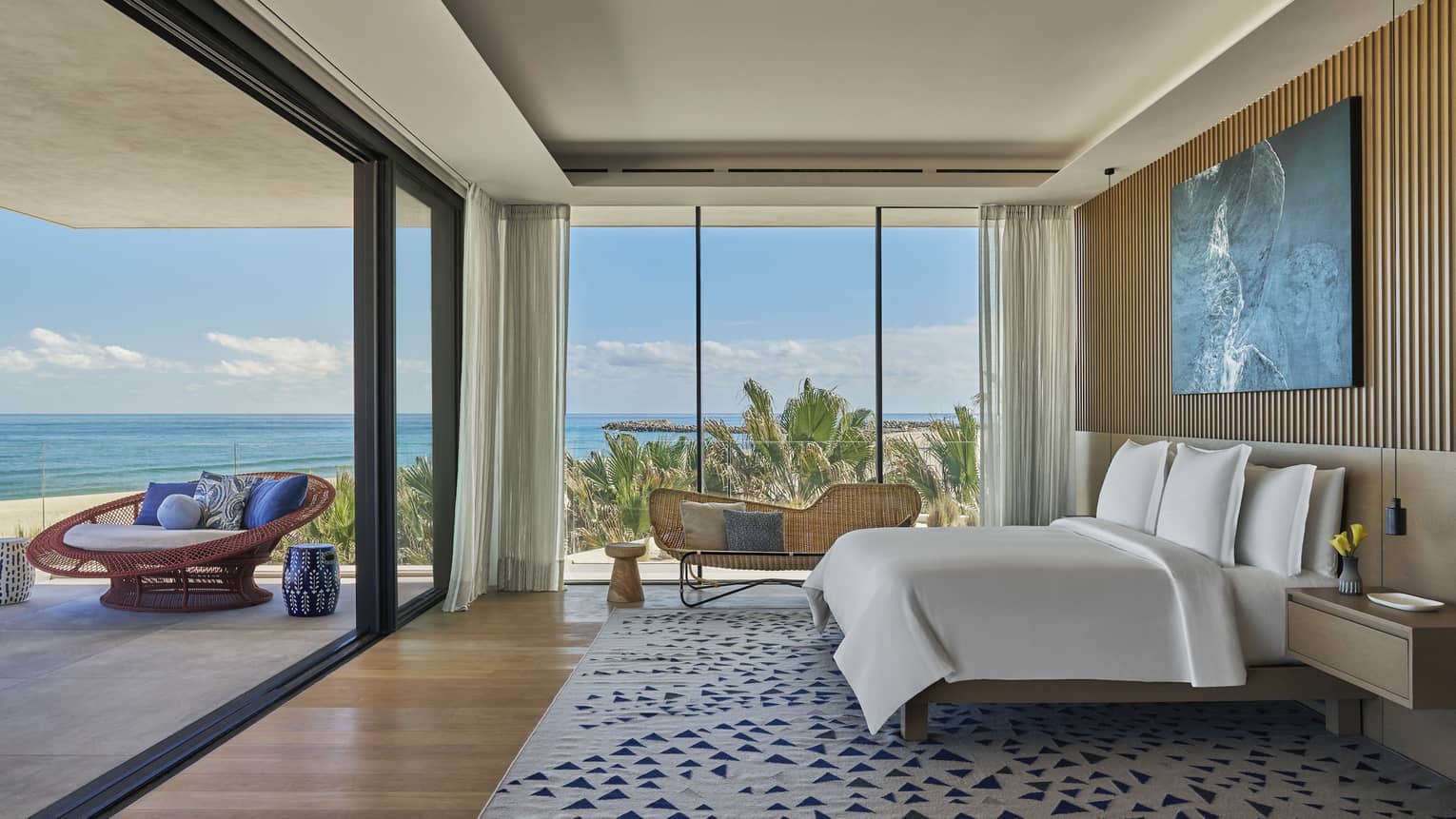 Large bedroom with king beds, walls of windows/sliding glass door to a private terrace with sea view, at Four Seasons Resort and Residences Los Cabos