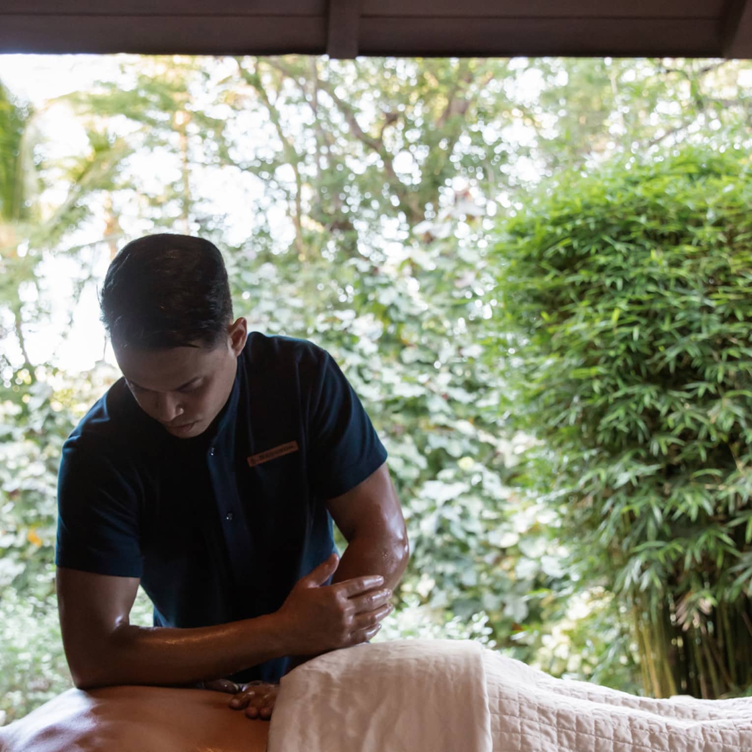 Man performs massage with elbow on back