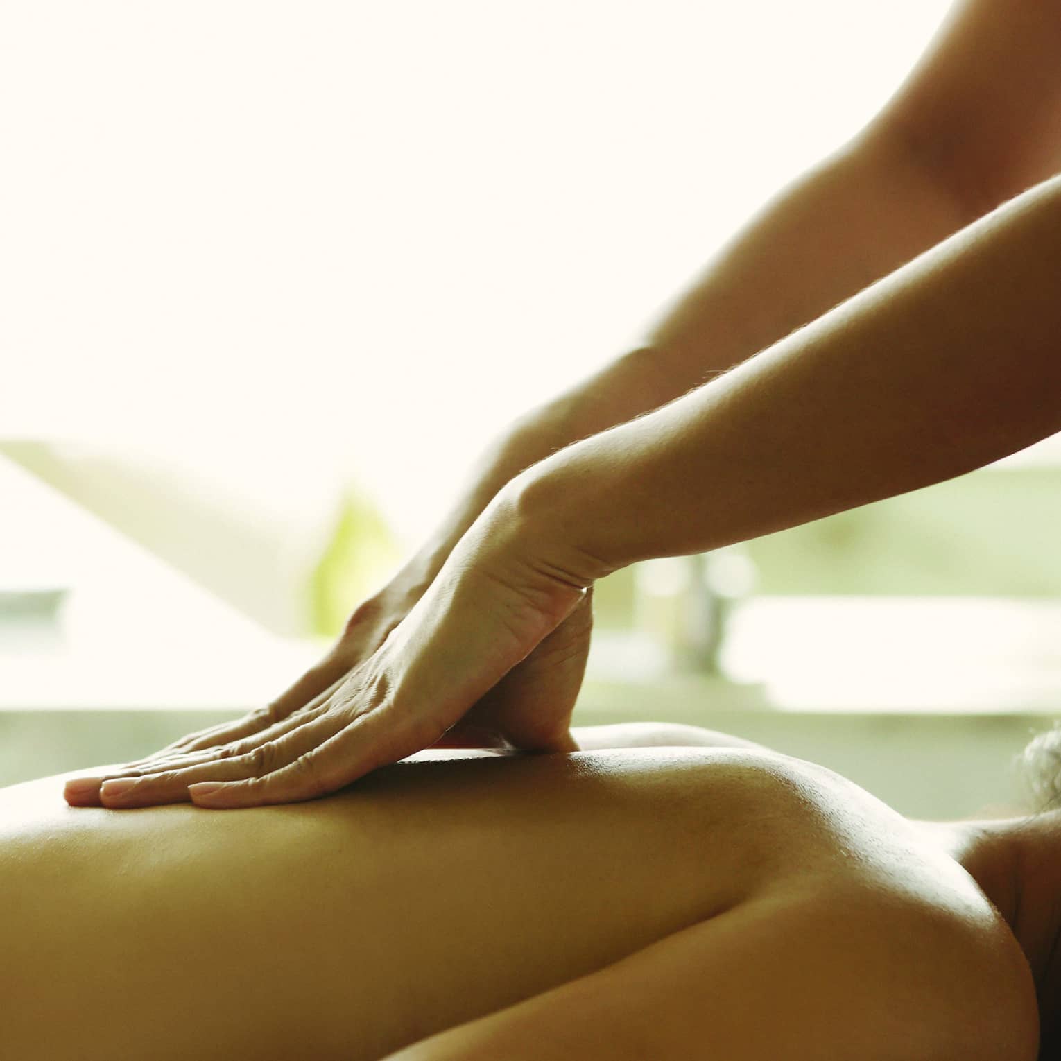 Close-up of a person receiving a relaxing back massage in a spa setting.