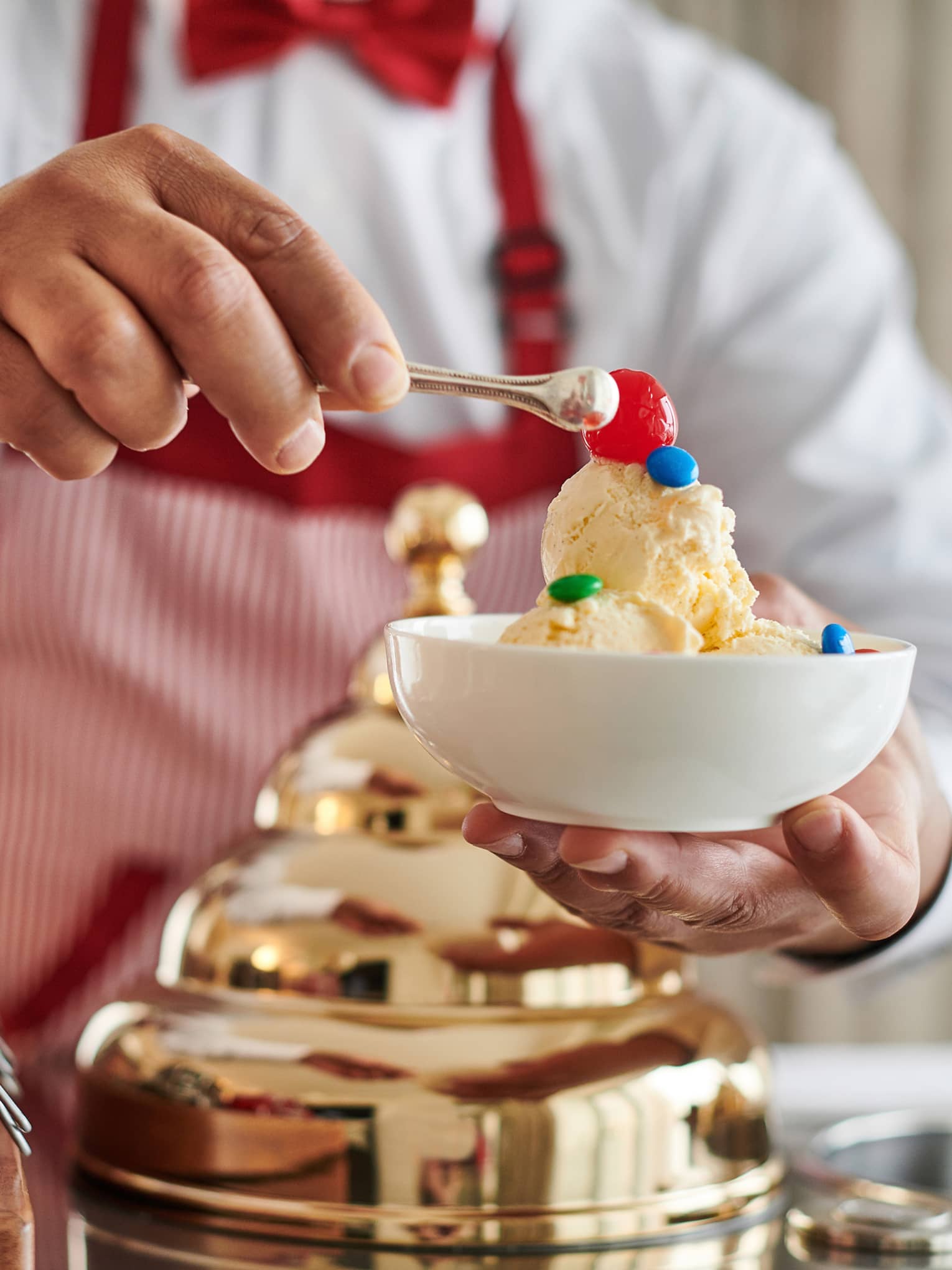 Man making an ice cream sundae from a retro Ice Cream Cart