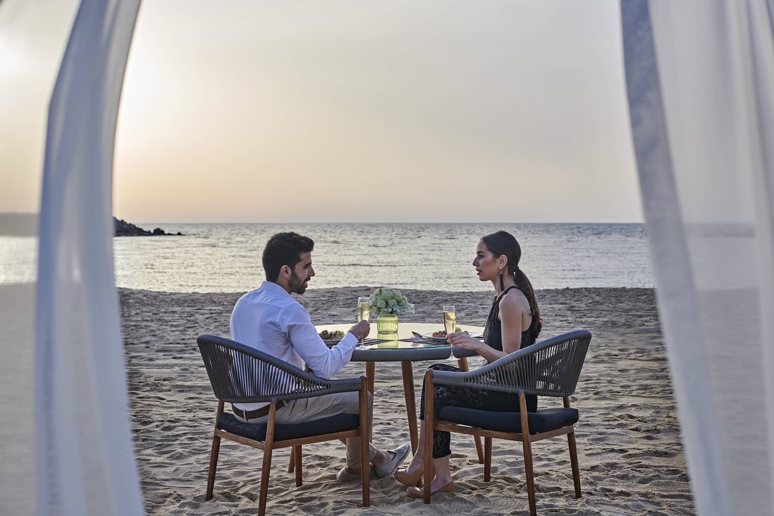 A couple has a romantic dinner for two on the beach at four seasons alexandria