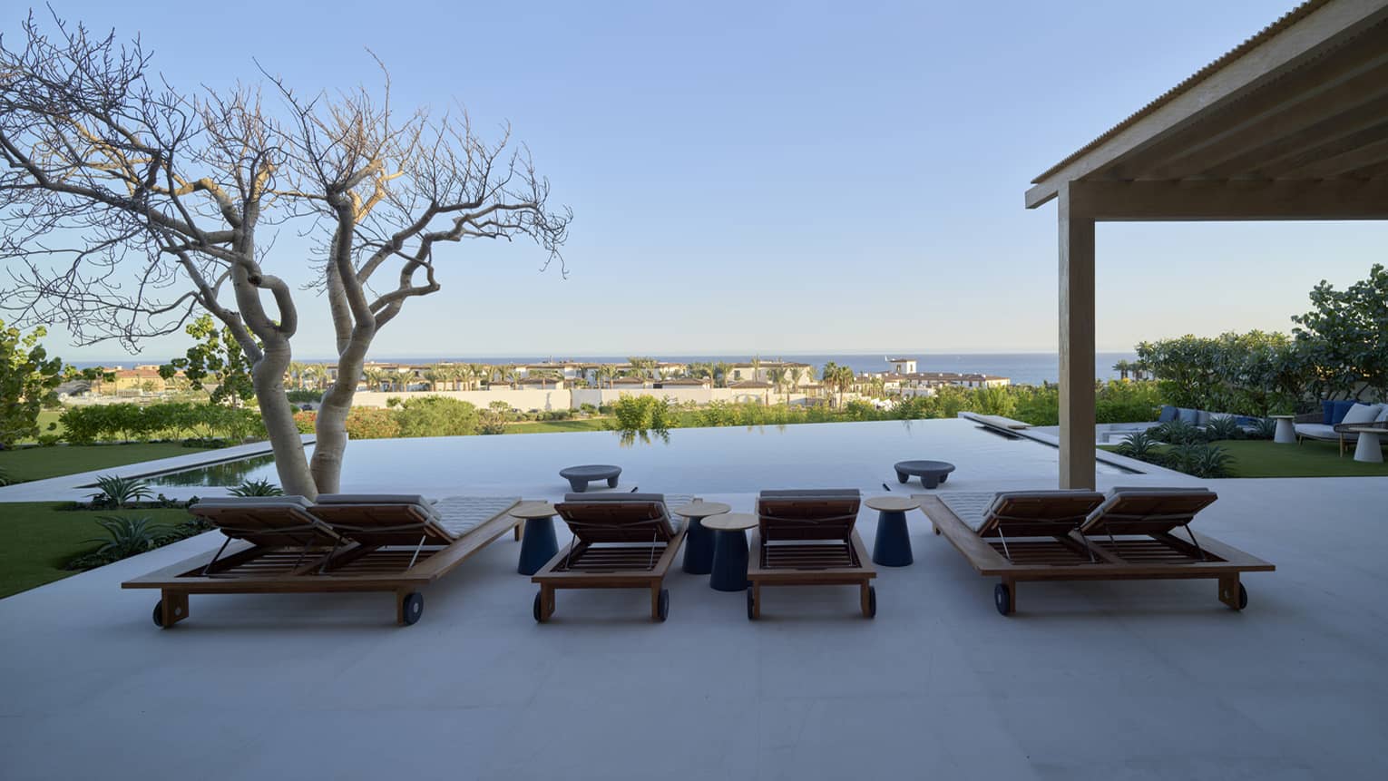 Sea-view pool terrace with sun loungers and covered dining area