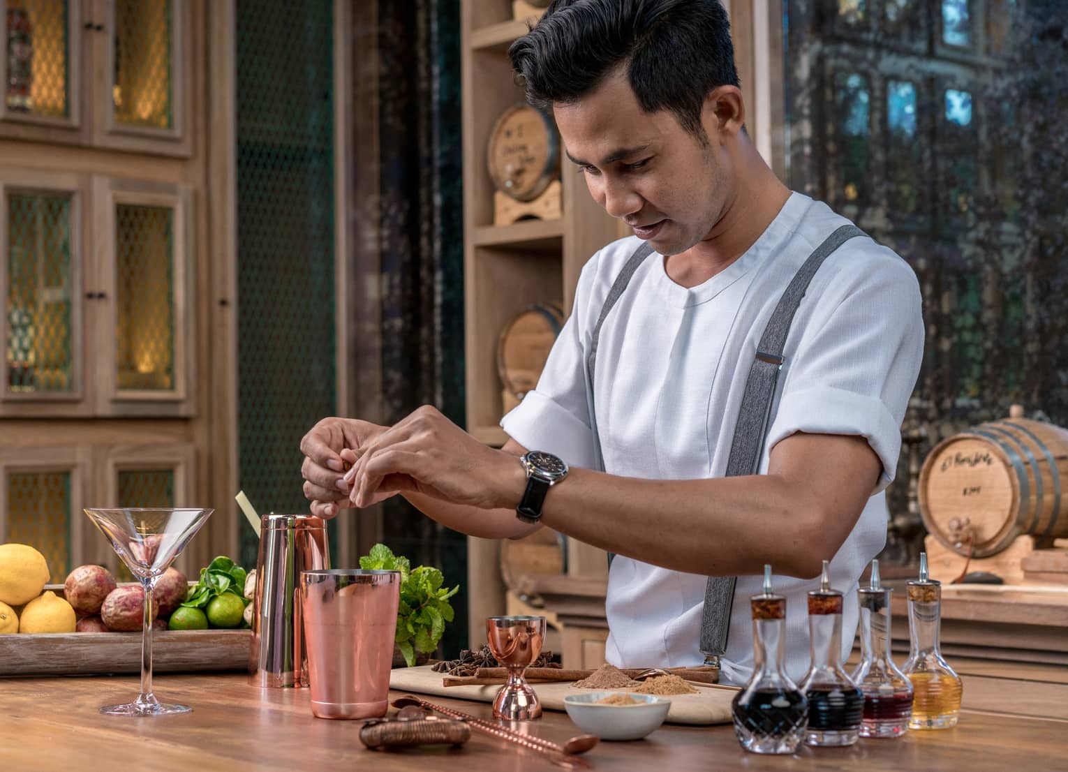 Bartender adds fragrant spices to a copper shaker in preparation for a cocktail 