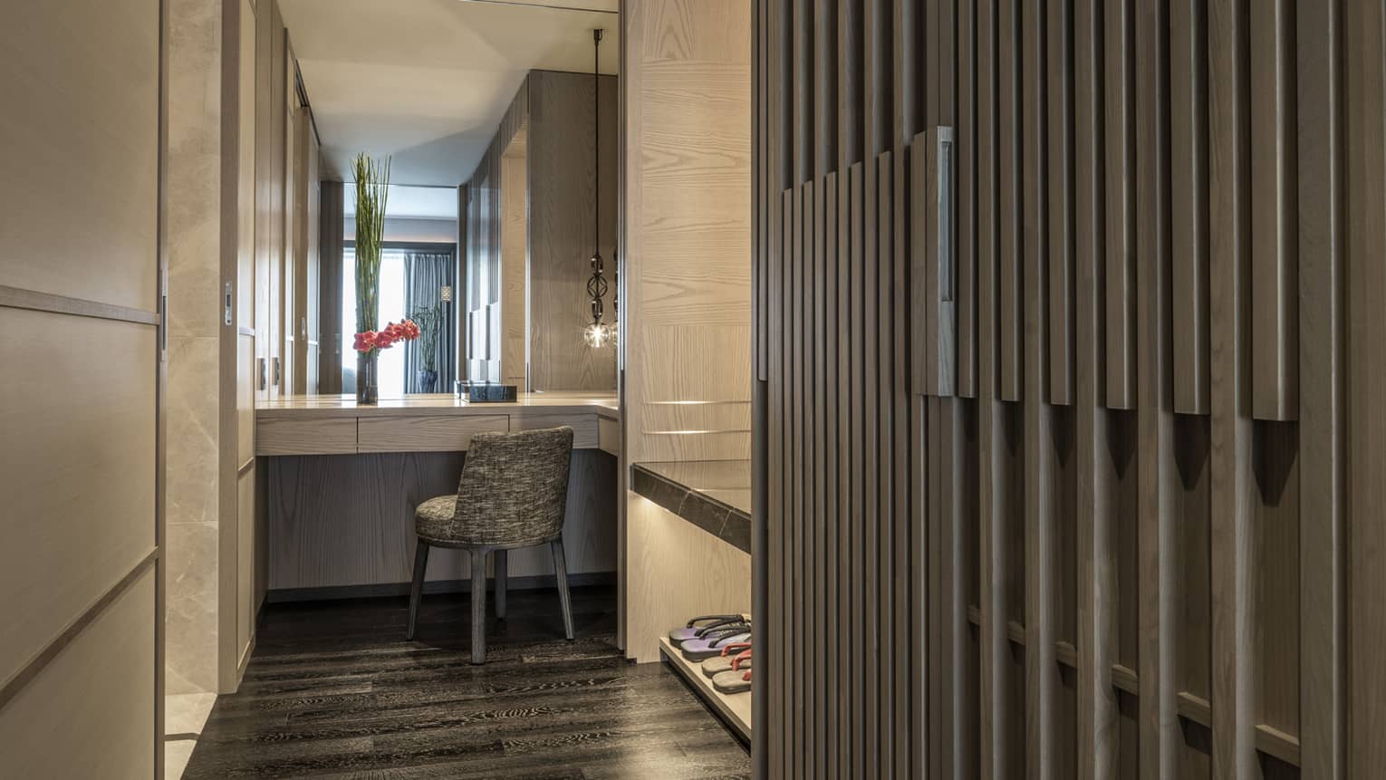 Elegant hallway with a vanity area, featuring a mirror, chair and decorative lighting