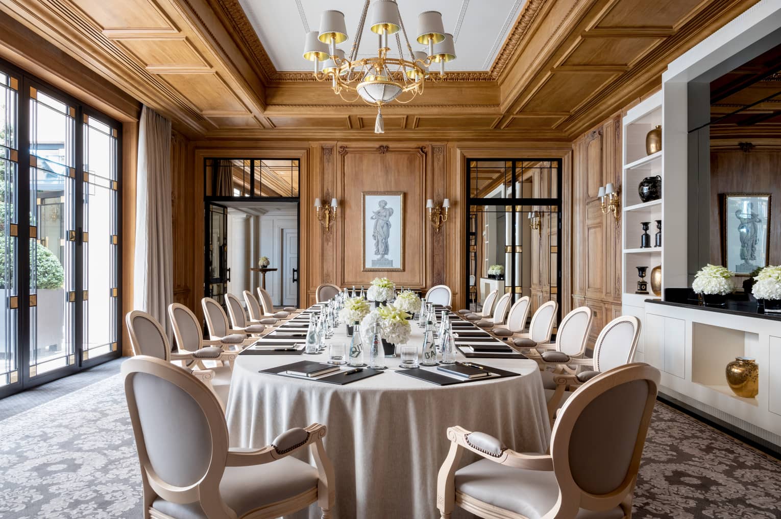 Long dining table, chairs in bright Napoléon meeting room with large windows