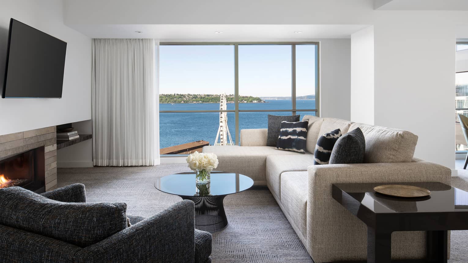 The living room's floor-to-ceiling windows look at to Elliot Bay in the Deluxe Elliot Bay Suite