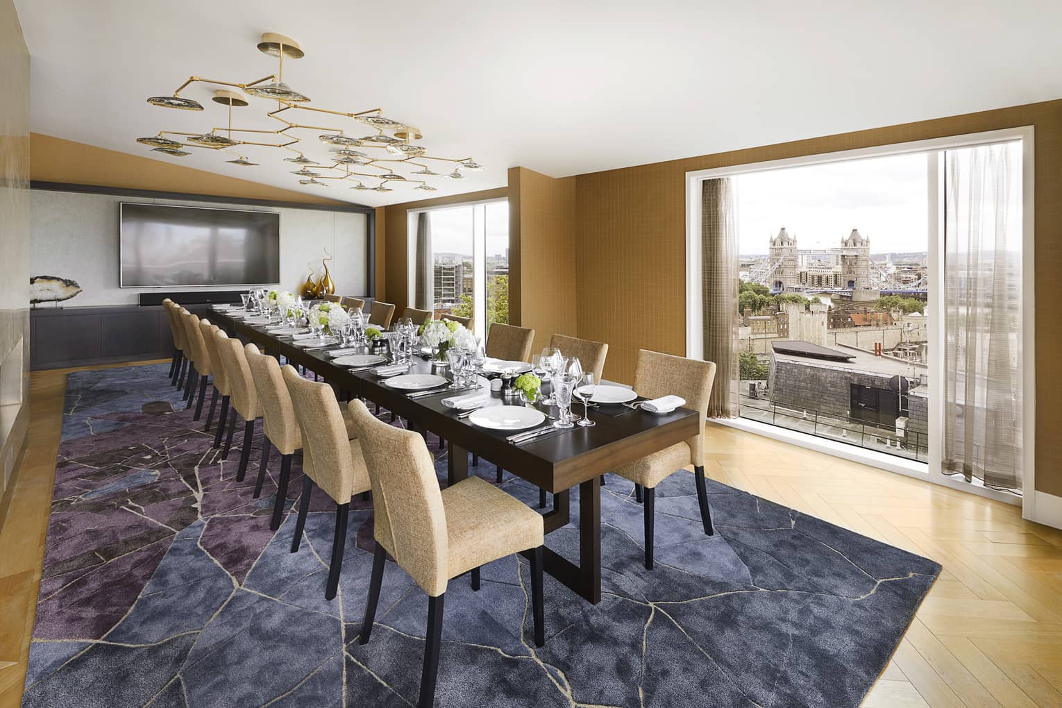 Elegant function space with rectangular conference table set for dinner under modern lighting with views of Tower Bridge