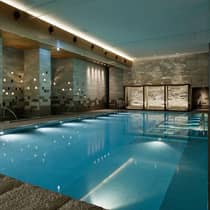 Indoor swimming pool with modern stone walls and ambient lighting at Four Seasons