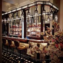 Elegant bar featuring vintage lanterns, hanging lights, stools and beautiful orchids