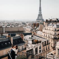 Couple embracing on Paris Hotel terrace with Eiffel Tower view