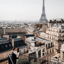 Couple embracing on Paris Hotel terrace with Eiffel Tower view