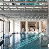 Indoor swimming pool under white beam ceiling, pillars