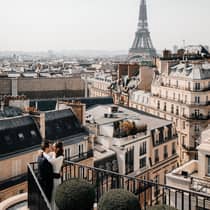 Couple embracing on Paris Hotel terrace with Eiffel Tower view