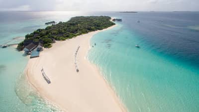 Aerial view of island with long white sand beach and turquoise water, Four Seasons Hotel Maldives at Landaa Giraavaru