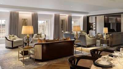 Large neutral living room with two seating vignettes flanked by lamps on side tables