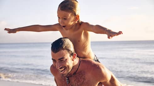 Older and younger guests laughing while on the beach