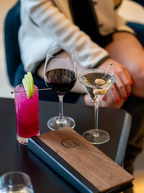 Three beverages on a table, one of them pink in colour.