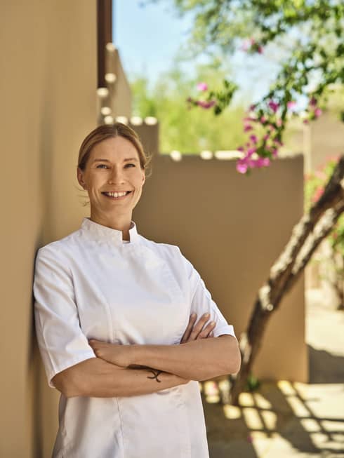 A chef poses outdoors in the sunshine